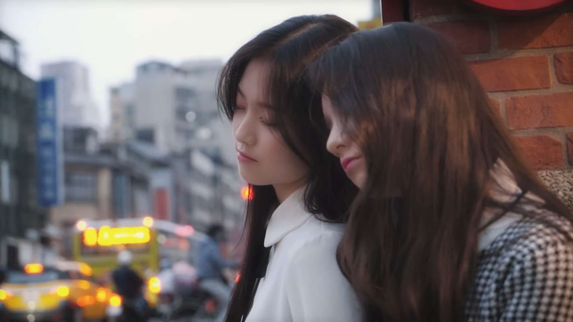 Heejin and Hyunjin leaning against each other.